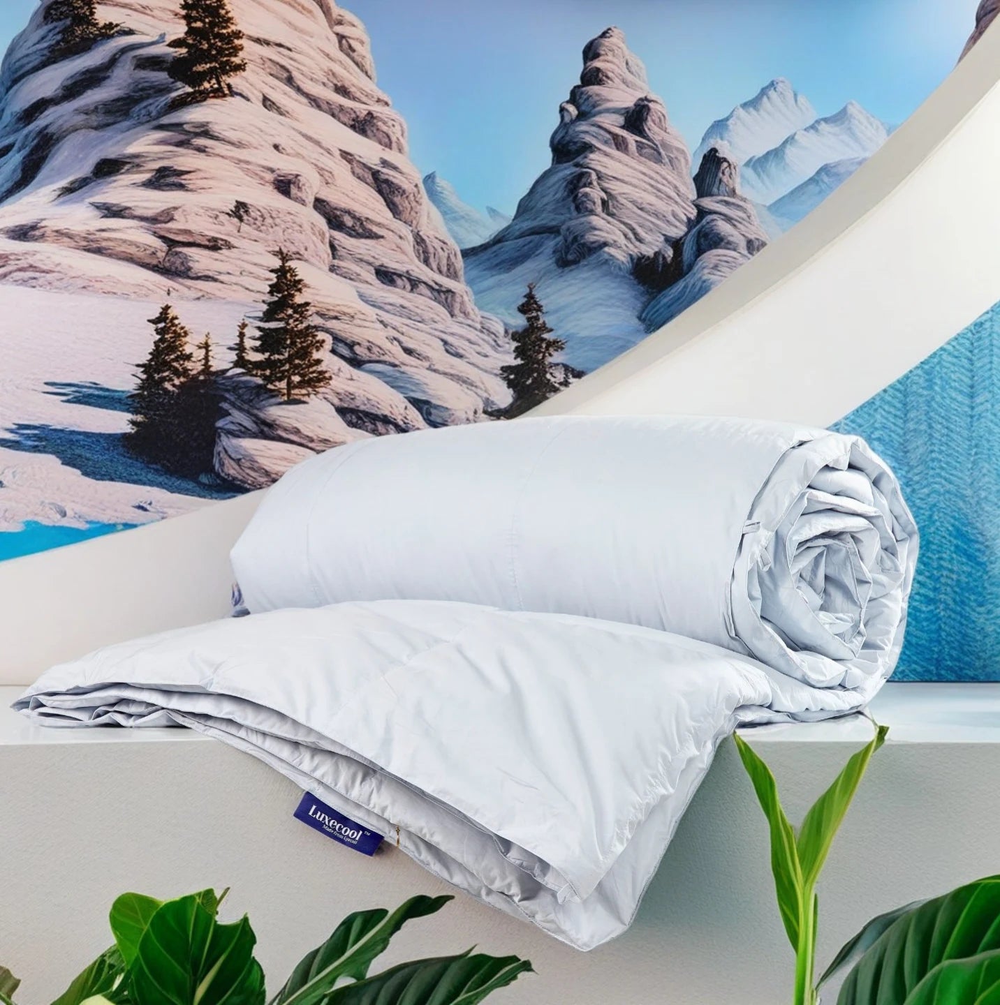 Rolled and folded light blue LuxeCool cooling bedding displayed against a snowy mountain backdrop